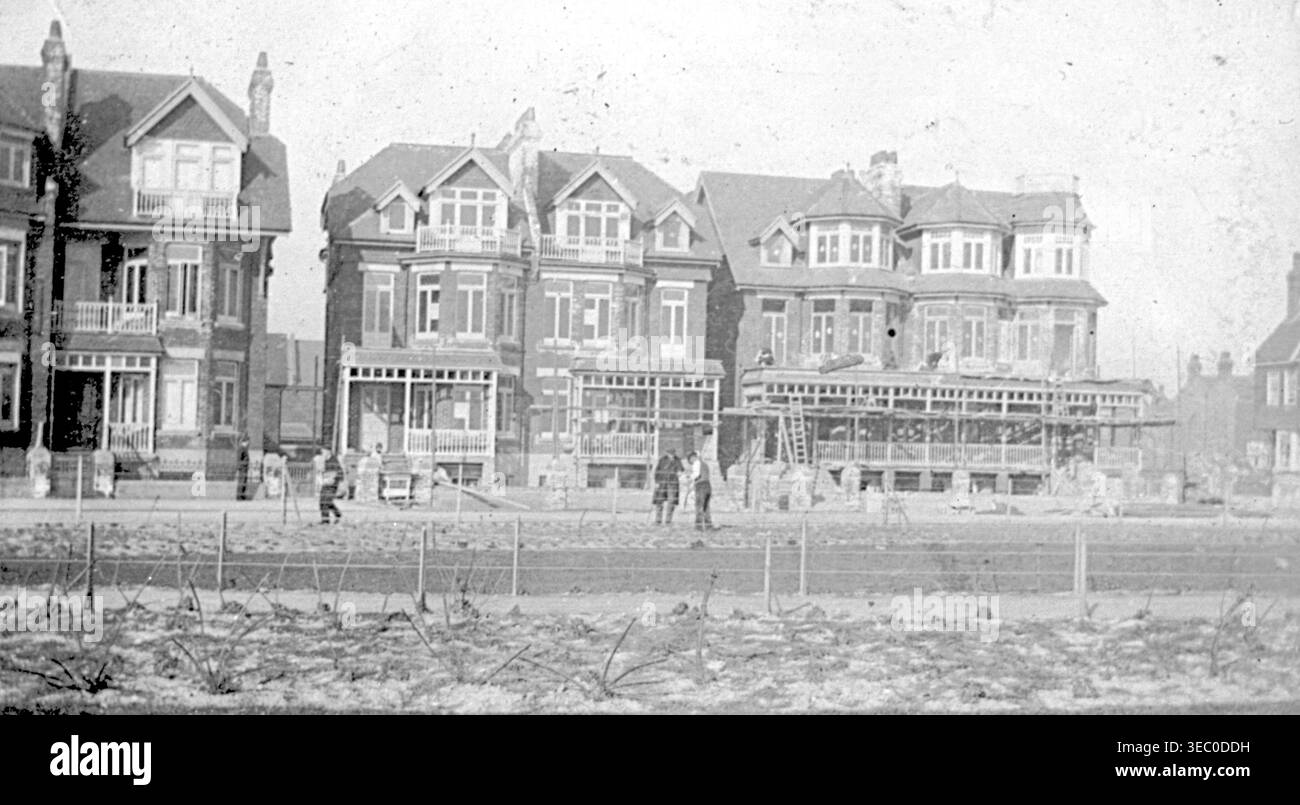 Grandi edifici a più piani in mattoni sorgono nel 1899 con finestre a bovindo, balconi, portici e finiture ornamentali. Le persone camminano o si alzano davanti a loro su un terreno irregolare delimitato dalla recinzione. La strada in primo piano e in via di sviluppo creano una scena urbana strutturata ma transitoria del primo secolo. Da un album tardo vittoriano di piccole fotografie scattate da un fotografo amatoriale. La maggior parte risale tra il 1898 e il 1901 e sembra riferirsi alla famiglia di John White (forse di Sth London), costruttore e imprenditore. La qualità delle fotografie originali era variabile e molte erano sbiadite e scolorite. Foto Stock