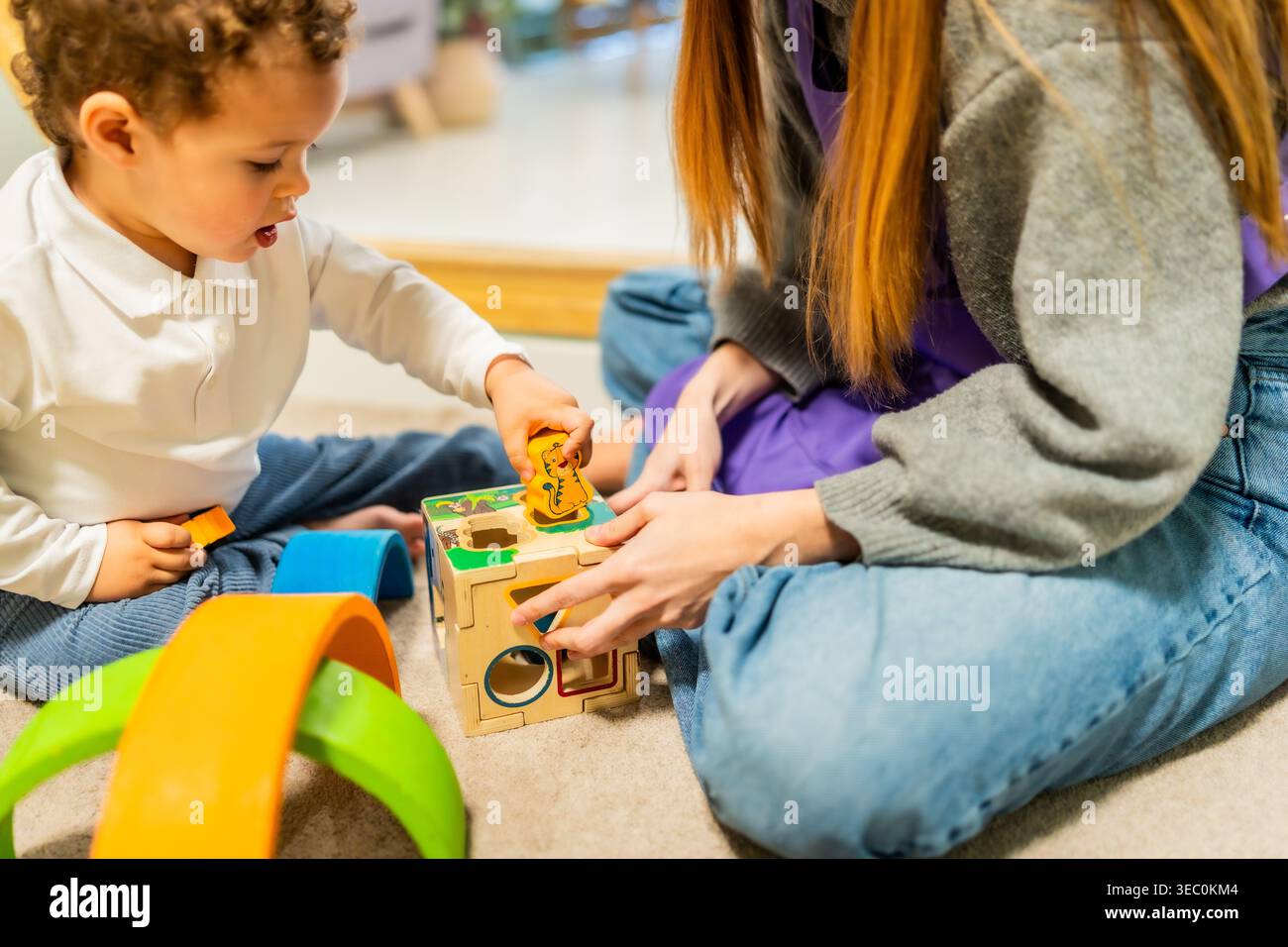 Il bambino gioca con il giocattolo dello smistatore di forma all'asilo Foto Stock