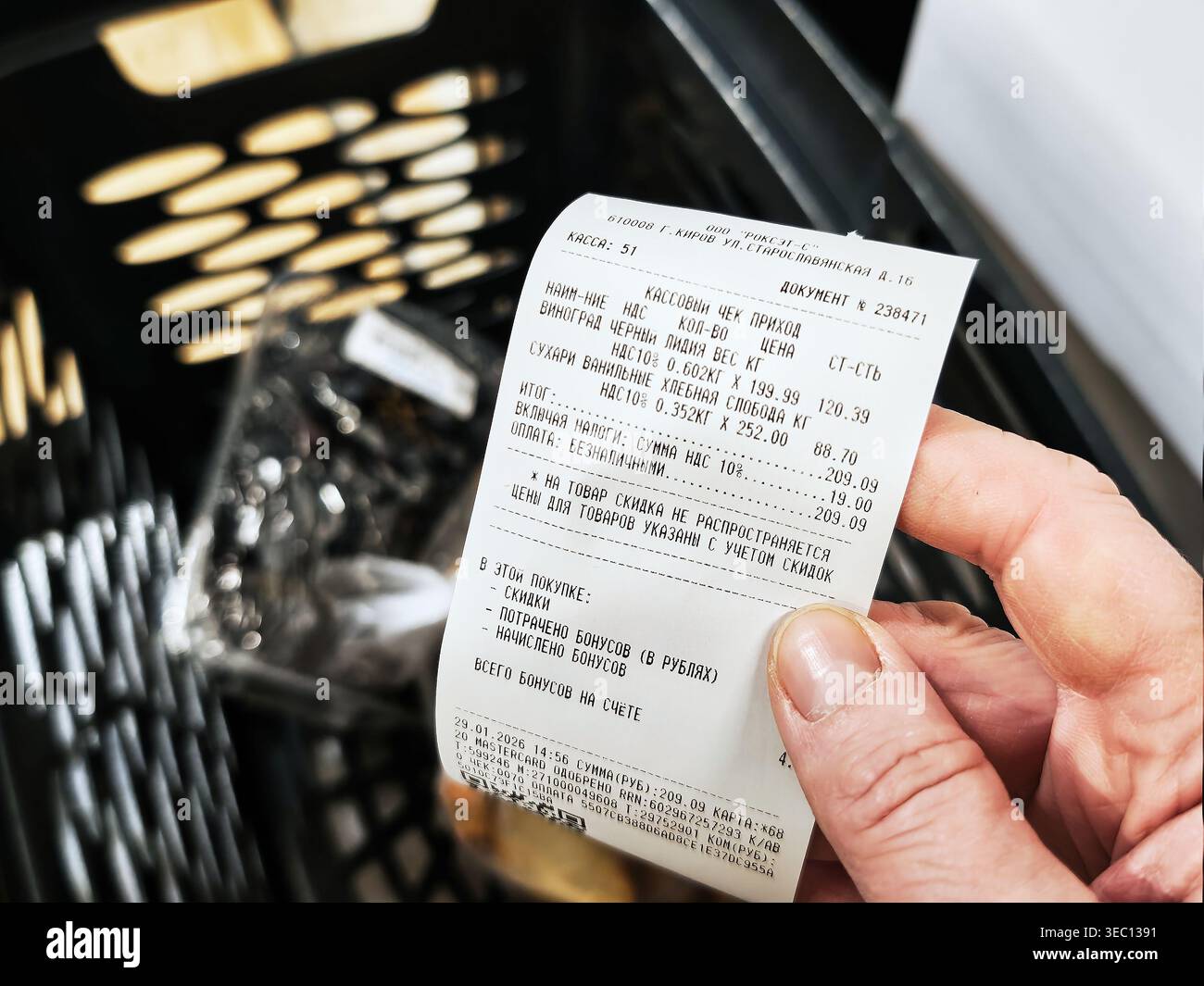 Kirov, Russia - 29 gennaio 2026: Una mano tiene una ricevuta del negozio che documenta gli articoli acquistati in un supermercato, indicando le spese totali per lo shoppin Foto Stock