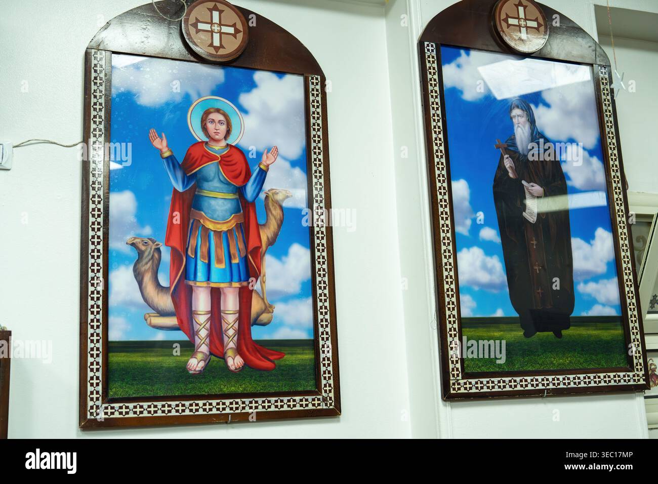 Marsa Alam, egitto 21 aprile 2026: Icone copte ortodosse raffiguranti santa mina la wonderworker con i cammelli e sant'antonio il grande con una croce e sc Foto Stock