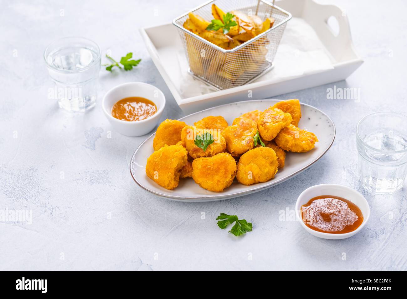 Pepite di pollo con patate fatte in casa e salse Foto Stock