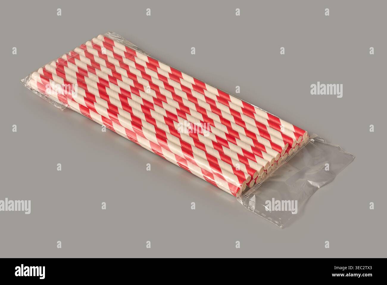 cannucce di carta a strisce rosse e bianche con rivestimento in plastica trasparente su sfondo grigio, materiali di consumo ecologici per feste, vista angolare modello mock-up Foto Stock