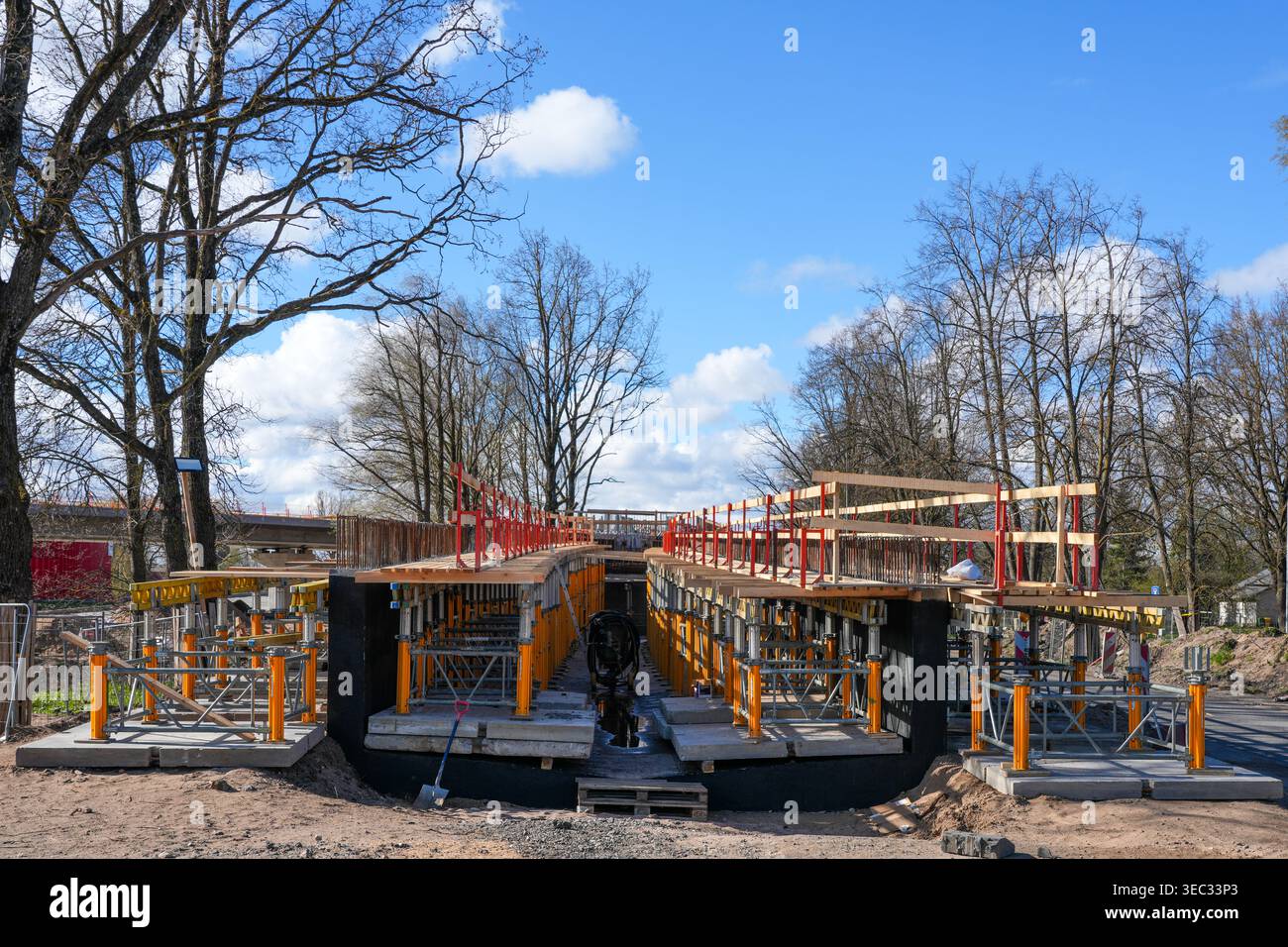 Ponte in costruzione con struttura di supporto per ponteggi e corrimano di sicurezza sotto il cielo blu Foto Stock