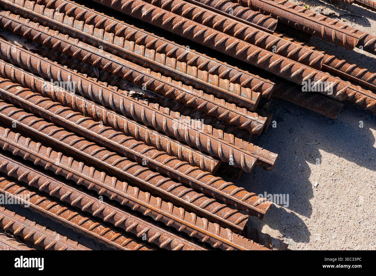 Barre di rinforzo in acciaio arrugginito impilate in cantiere pronte per lavori in calcestruzzo Foto Stock