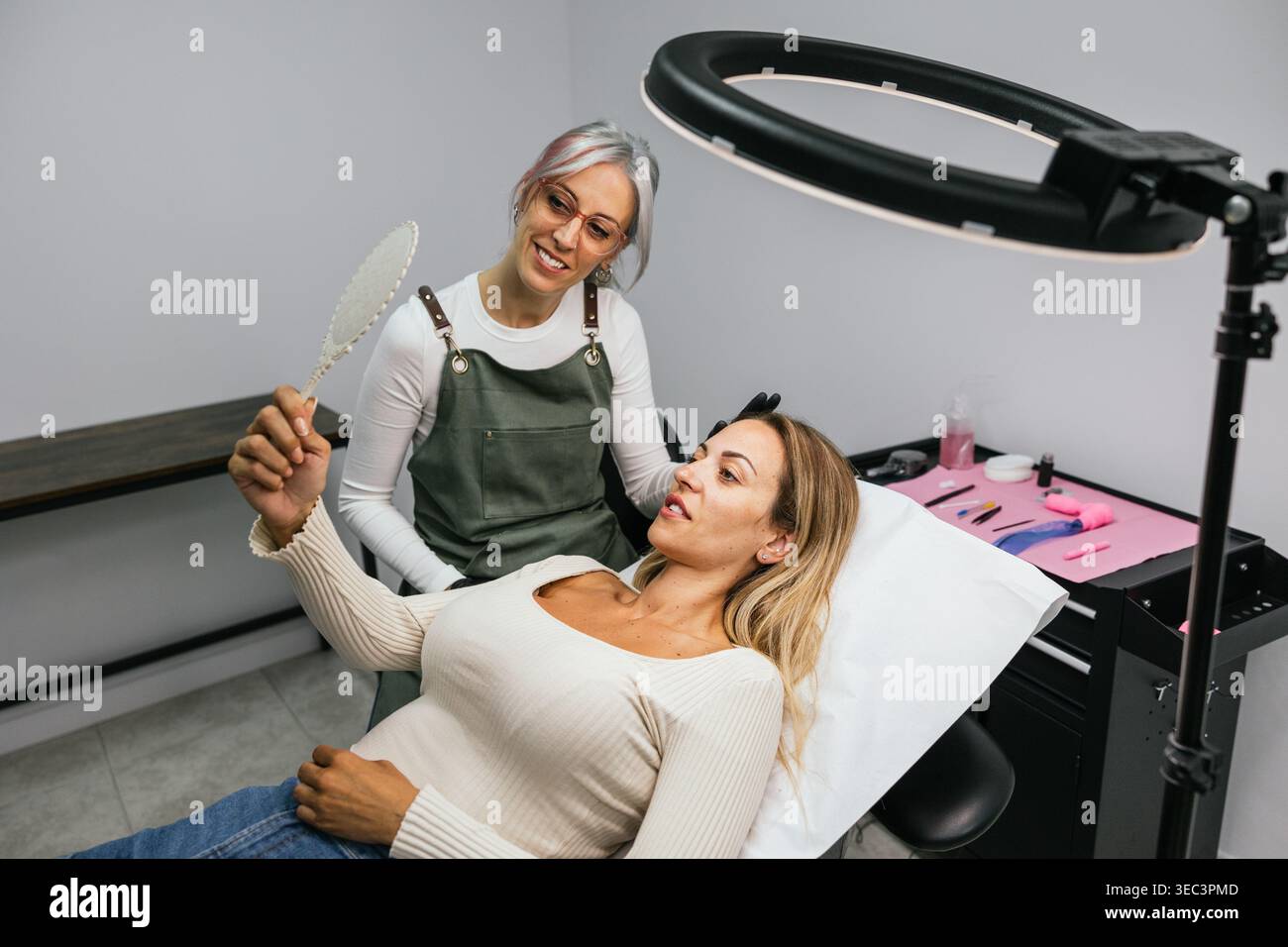 Cliente soddisfatto ammirando le nuove sopracciglia a microlama Foto Stock