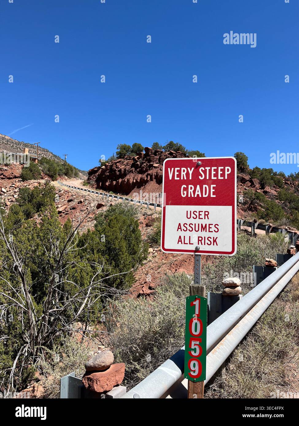 Cartello segnaletico stradale ripido l'utente si assume tutti i rischi, Jemez, New Mexico, Stati Uniti - Immagine stock catturata con smartphone