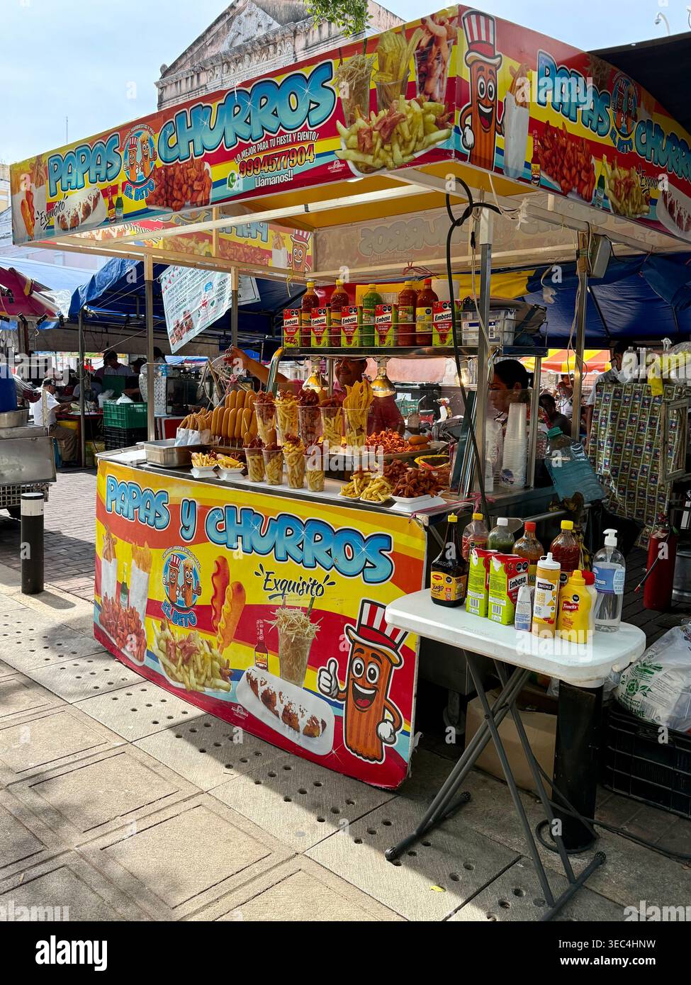Colorato banco di cibo di strada che vende papas e churros a Mérida, Yucatán, Messico Foto Stock