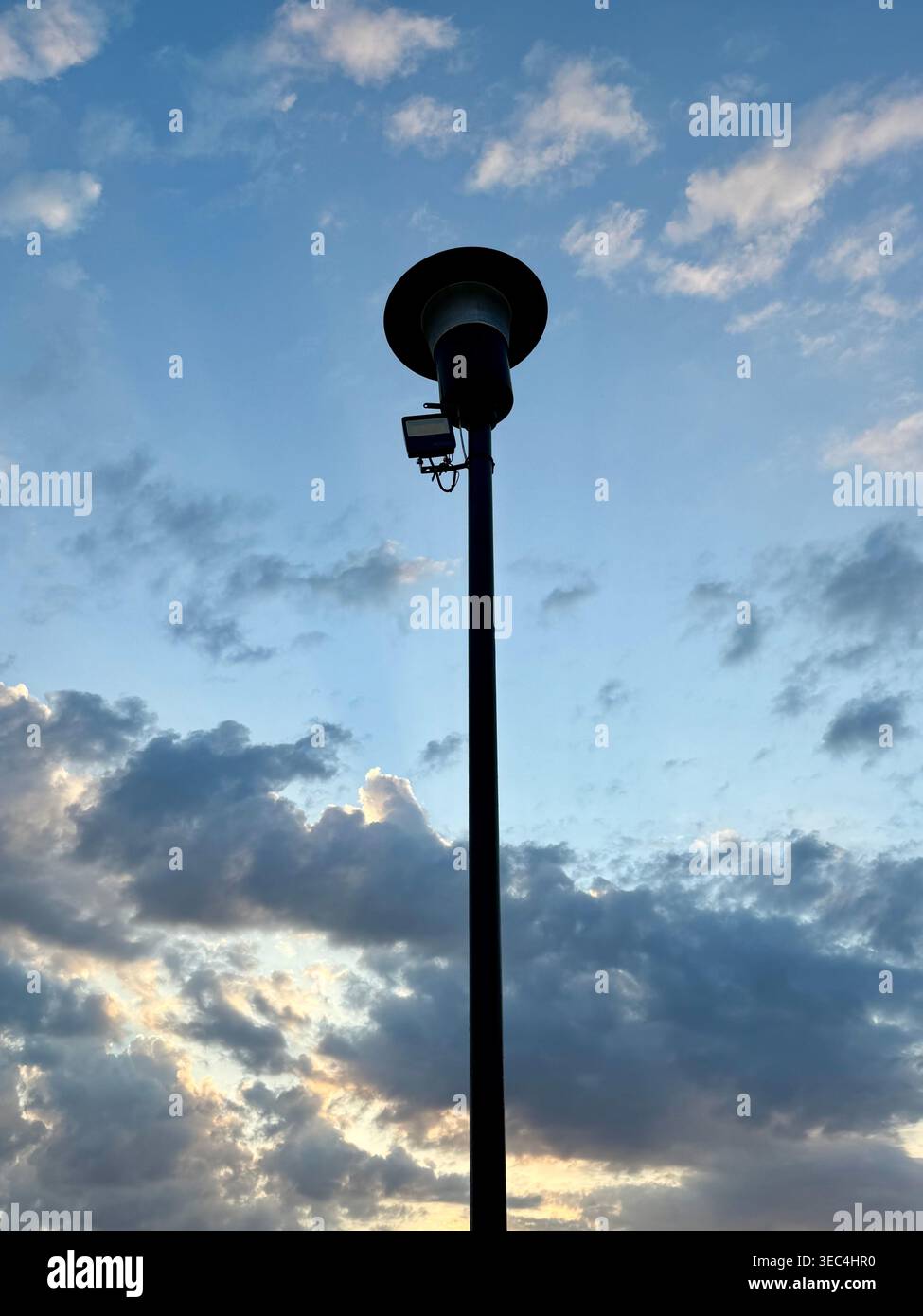 Lampada da strada a energia solare con silhouette che si abbina al cielo della sera Foto Stock