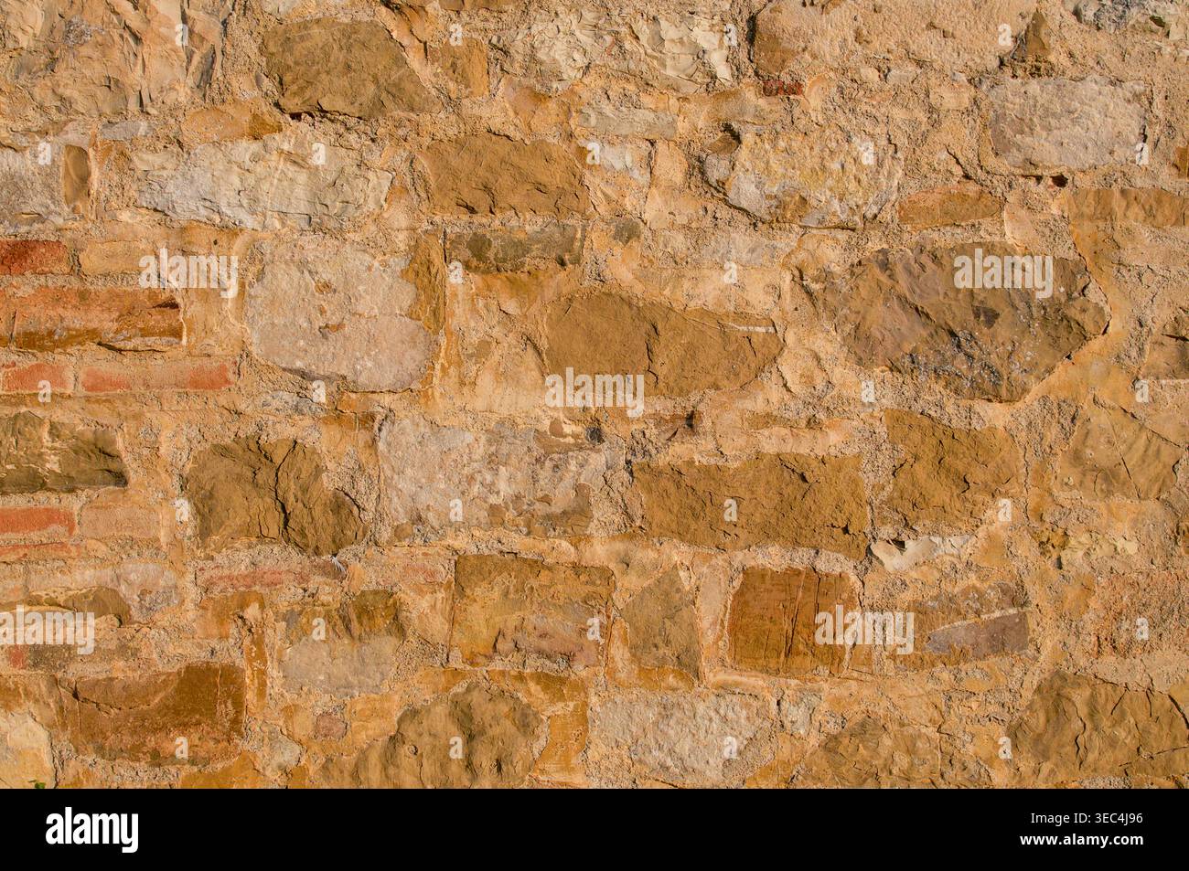 Struttura di un antico muro rustico fatto di pietra arenaria dai toni caldi e mattoni terrosi Foto Stock