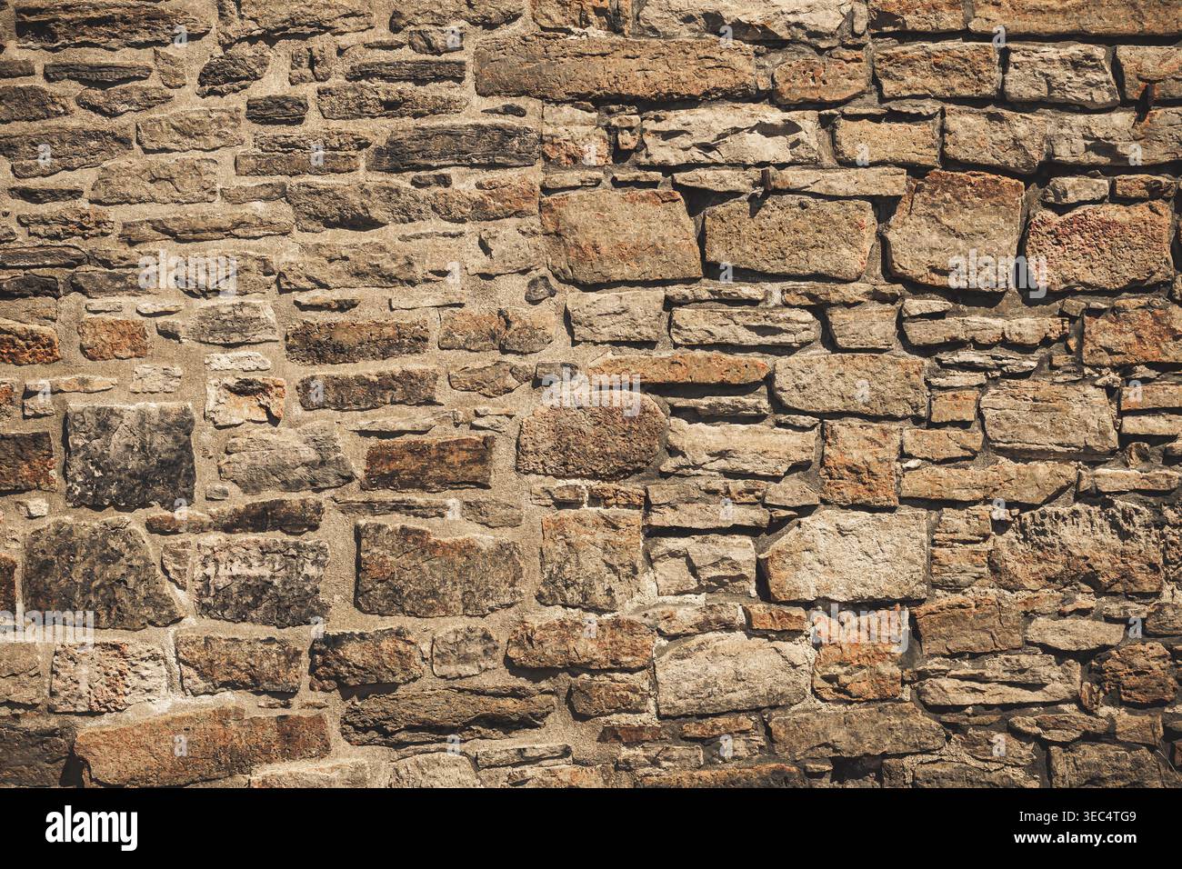 Pareti in pietra ruvida con varie dimensioni e sfumature naturali. Le pietre formano una superficie robusta e resistente agli agenti atmosferici. Le texture mostrano l'età e la maestria artigianale. Ideale per gli architetti Foto Stock