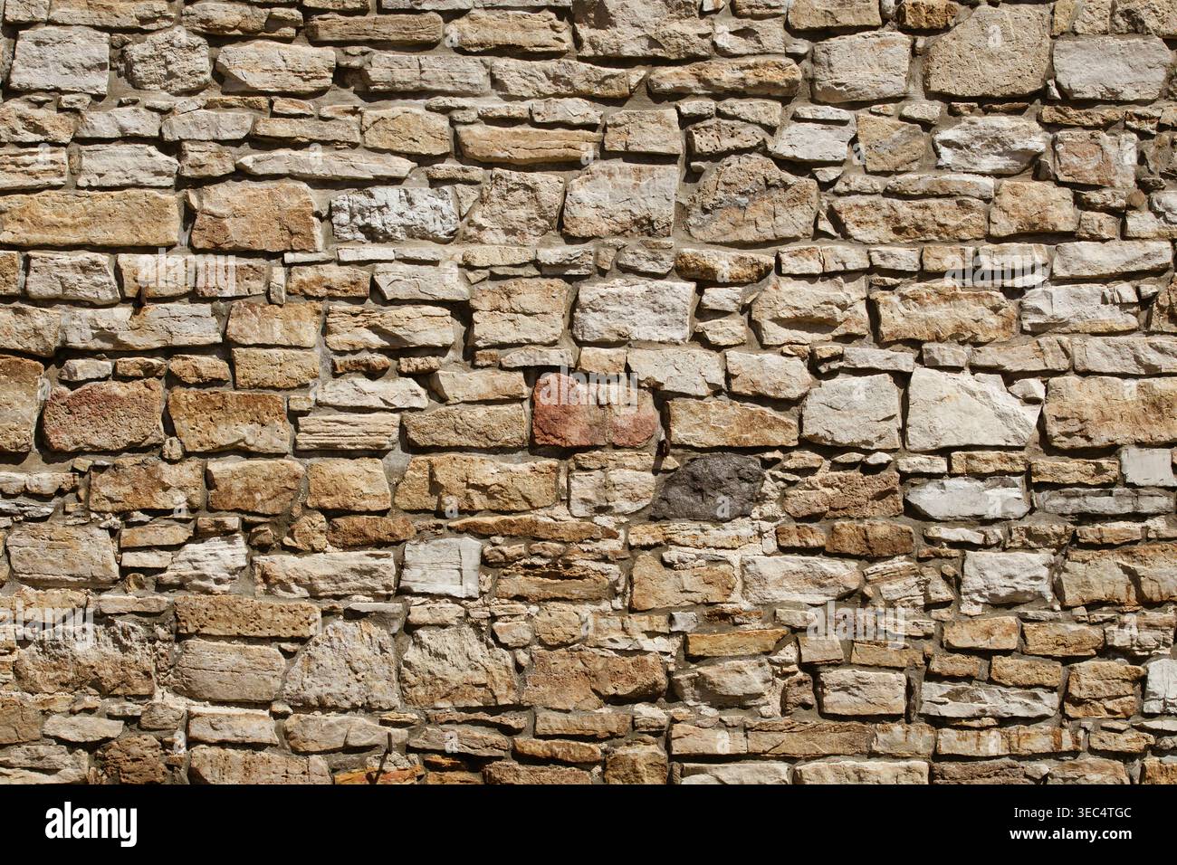 Pareti in pietra ruvida con varie dimensioni e sfumature naturali. Le pietre formano una superficie robusta e resistente agli agenti atmosferici. Le texture mostrano l'età e la maestria artigianale. Ideale per gli architetti Foto Stock