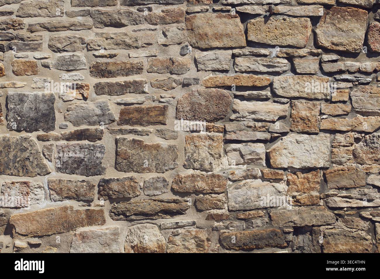 Pareti in pietra ruvida con varie dimensioni e sfumature naturali. Le pietre formano una superficie robusta e resistente agli agenti atmosferici. Le texture mostrano l'età e la maestria artigianale. Ideale per gli architetti Foto Stock