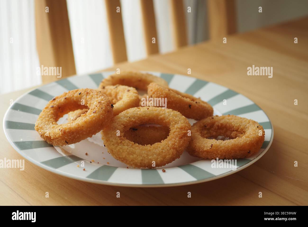 Anelli di cipolla fritti su un piatto in cucina Foto Stock