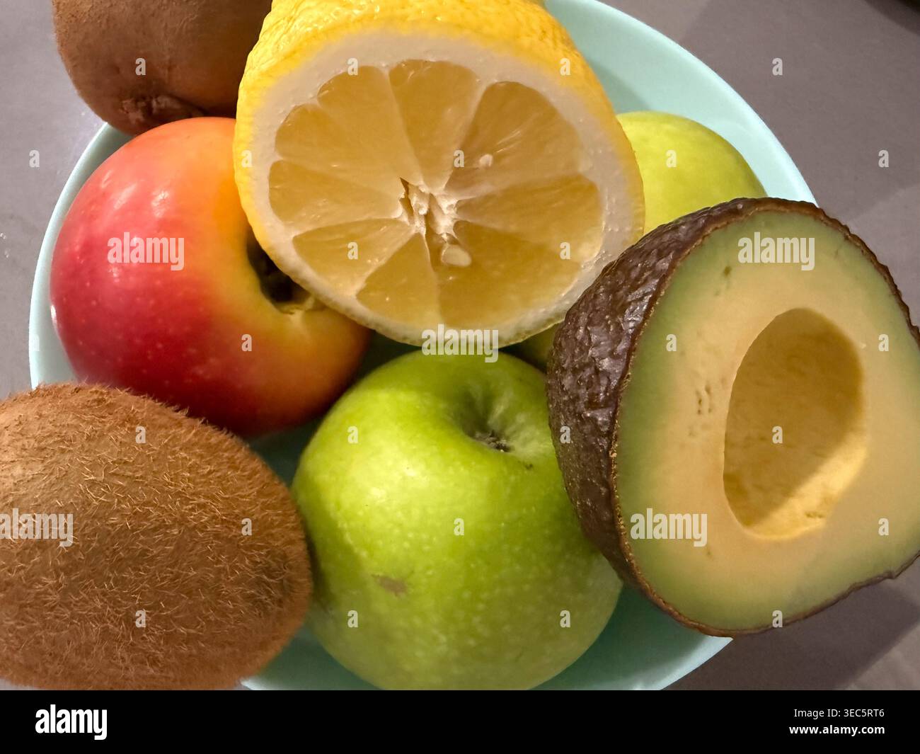 frutta fresca in ciotola su sfondo grigio banner concetto di cibo sano, alimentari, nutrizione Foto Stock