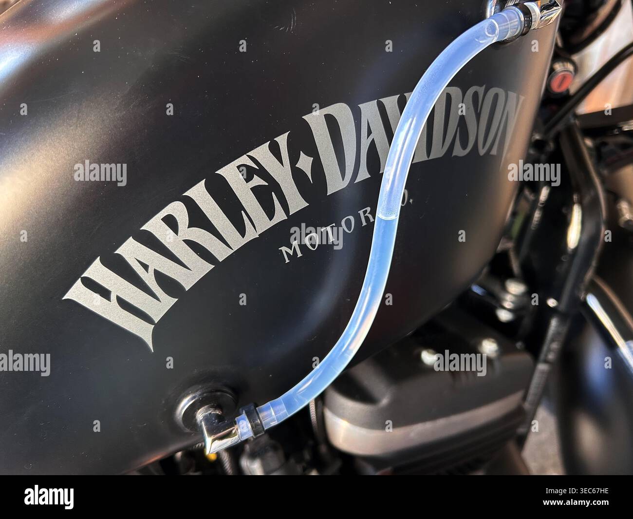 Primo piano di un serbatoio carburante per moto Harley-Davidson con logo visibile e tubo flessibile trasparente attaccato a Gdynia, Polonia, 27 aprile 2026 Foto Stock