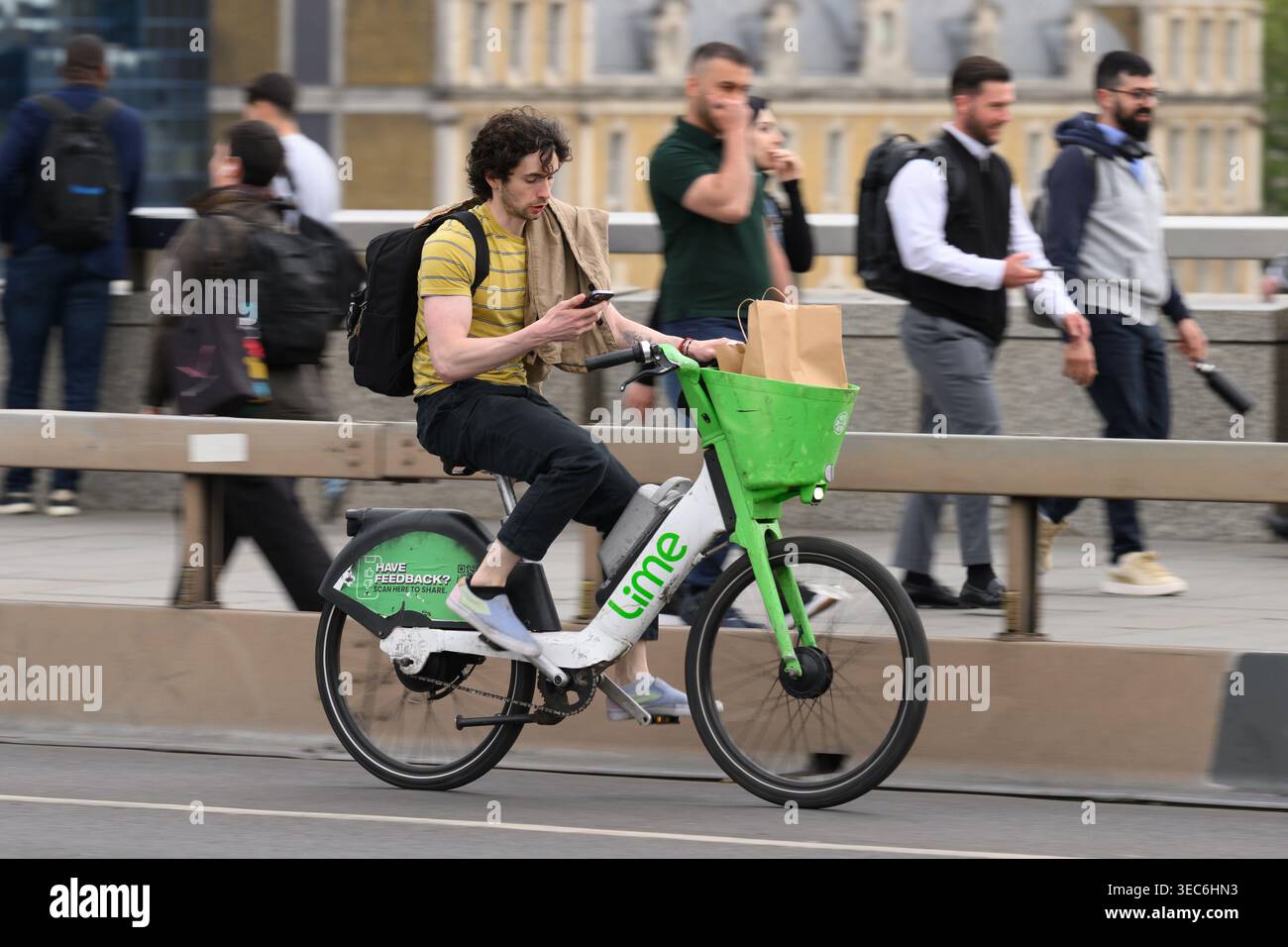Un uomo che viaggia su una bicicletta elettrica Lime attraverso il London Bridge durante l'ora di punta serale. London Bridge, Londra, Regno Unito. 27 aprile 2026 Foto Stock