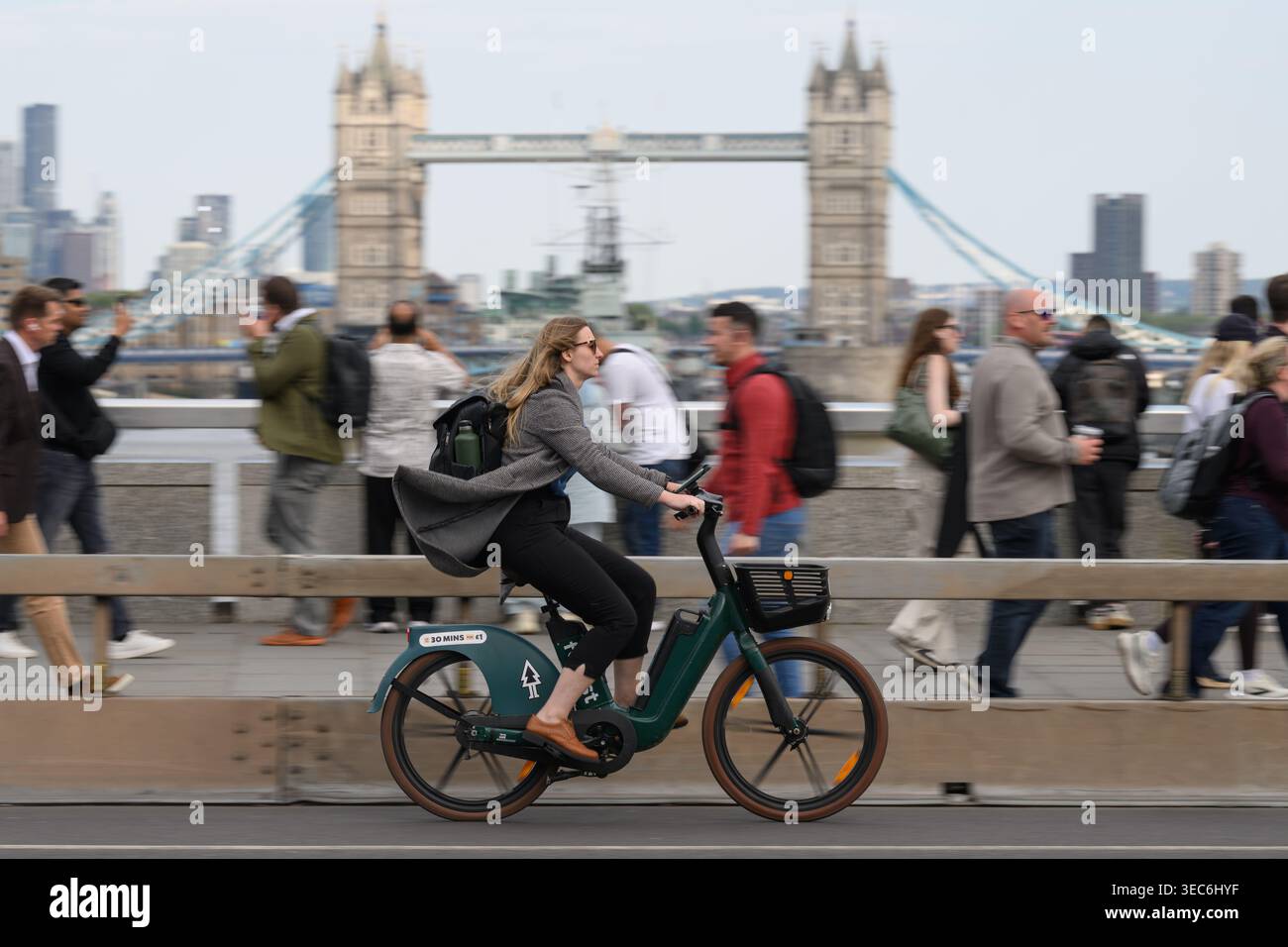 Una donna che viaggia su una bicicletta a noleggio nella foresta attraverso il London Bridge durante l'ora di punta serale. London Bridge, Londra, Regno Unito. 27 aprile 2026 Foto Stock