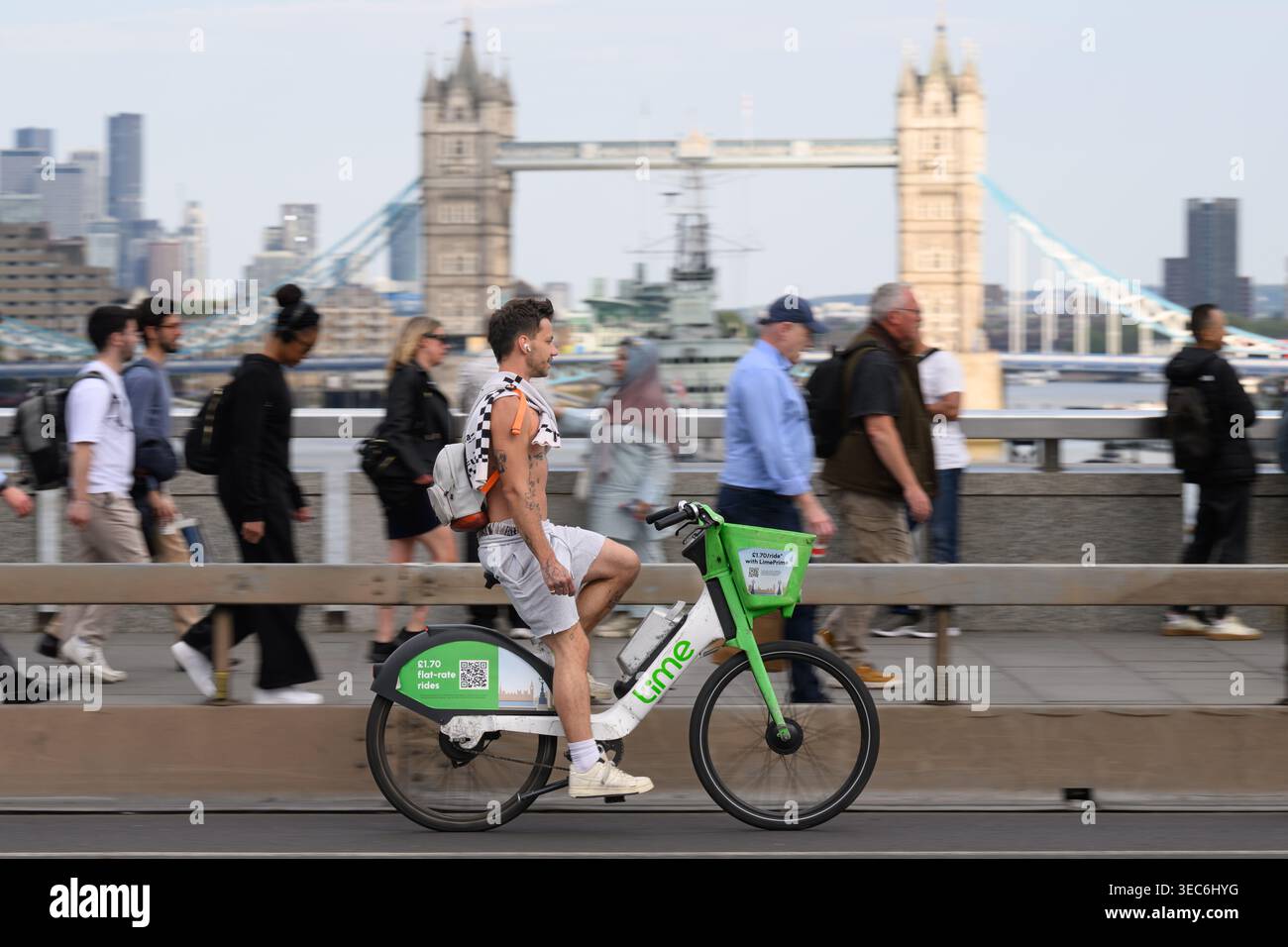 Un uomo che viaggia su una bicicletta elettrica Lime attraverso il London Bridge durante l'ora di punta serale. London Bridge, Londra, Regno Unito. 27 aprile 2026 Foto Stock