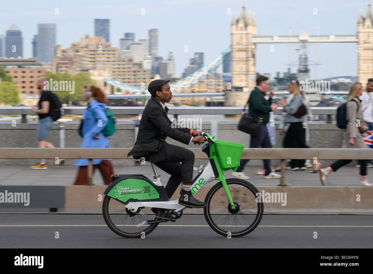Un uomo che viaggia su una bicicletta elettrica Lime attraverso il London Bridge durante l'ora di punta serale. London Bridge, Londra, Regno Unito. 27 aprile 2026 Foto Stock