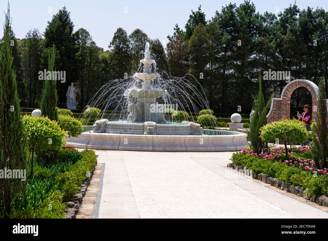 I visitatori potranno fare una piacevole passeggiata attraverso un parco botanico illuminato dal sole, dove aiuole uniche delimitate da corde e ampi campi di rosso e orang vibranti Foto Stock