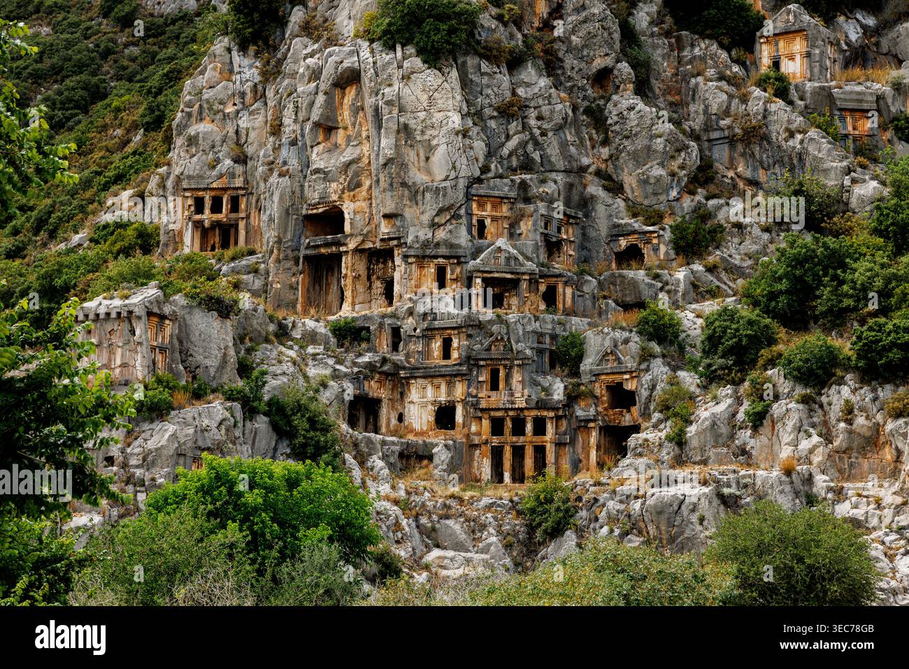 Un'ampia foto del famoso sito archeologico che mostra monumenti funerari storici scolpiti direttamente nella ripida parete rocciosa della montagna. Foto Stock