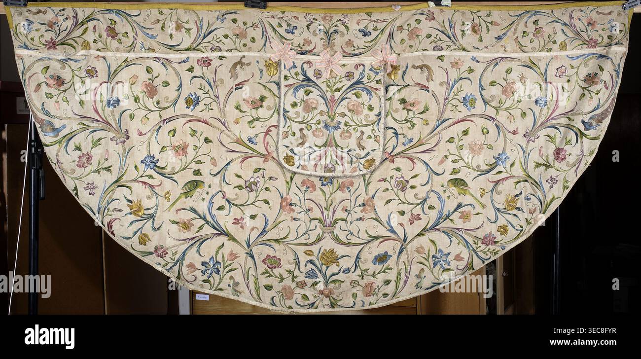 Church Cope, Cope in tessuto di seta ricamato con supporto e fodera in lino; il fondo di seta originale si è sbriciolato e il ricamo è conservato grazie a un supporto di lino sottostante. La decorazione ricamata riempie completamente la superficie con un motivo di tendini frondosi e fiori rose, tulipani, garofani. Sagome di uccelli (pavoni, pappagalli, tacchini e altri) adornano i rami. Bordi rifiniti con treccia di seta gialla; cappuccio con fiocchi conservati di nastro di seta rosa. XVIII secolo, Slesia. Paramento liturgico. Lunghezza 139 cm, larghezza 287 cm, grande tessuto semicircolare con crema leggera Foto Stock