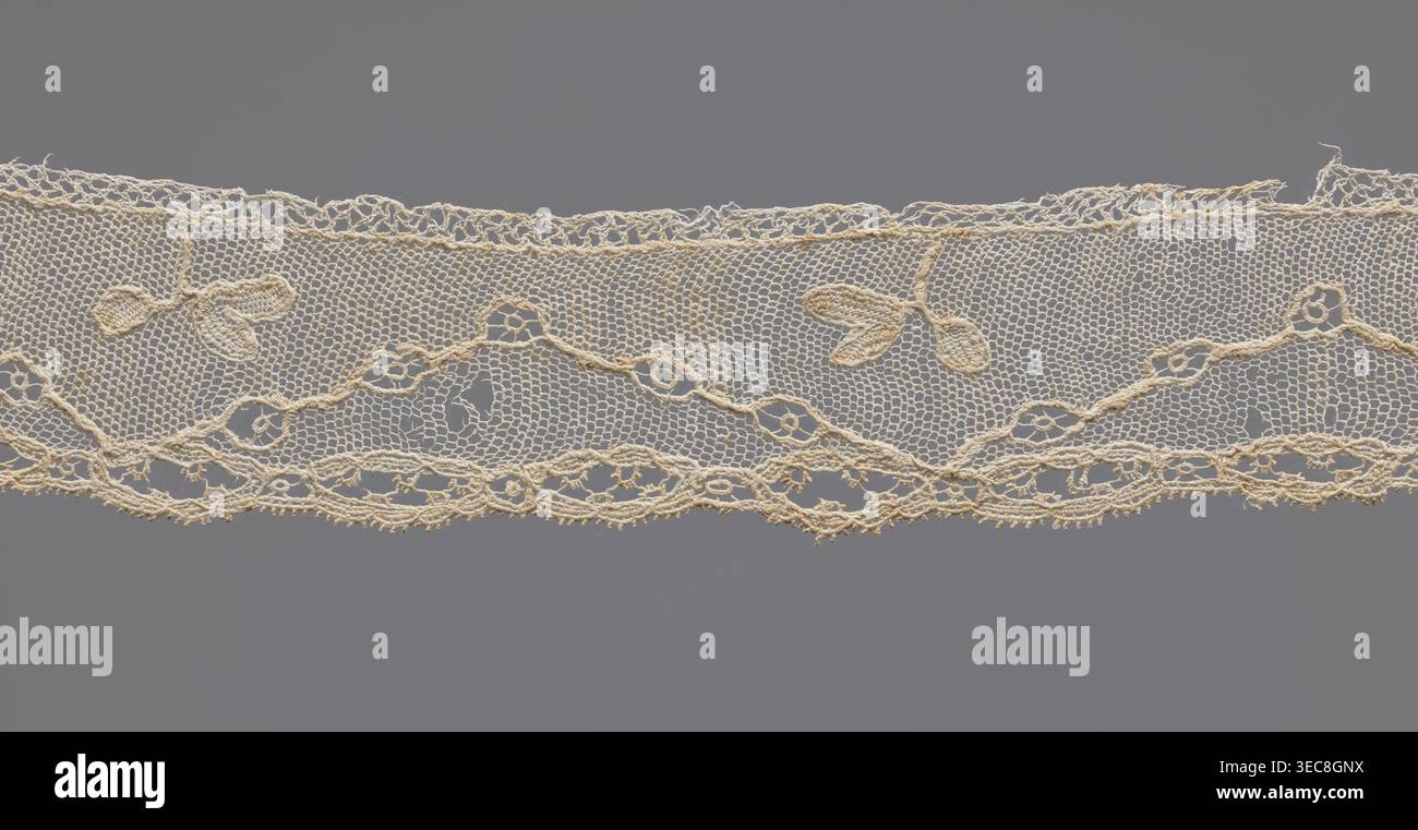 Frammento di pizzo, pizzo cucito ad ago, ovali a lavoro aperto molto allungati. Sopra l'ornamento del bordo, su uno sfondo mesh, una linea di avvolgimento interrotta da cerchi aperti. Nelle piegature della linea, una proiezione di ramo a tre foglie piuttosto grande. XVIII secolo, probabilmente in Francia. Larghezza 3,5 cm, lunghezza 42,5 cm., lunghezza orizzontale di delicato pizzo in un colore bianco scuro cremoso si estende su uno sfondo grigio, caratterizzato da una sottile trama esagonale con un bordo inferiore smerlato e un bordo superiore decorativo più morbido; il pizzo mostra un motivo floreale ripetuto con piccole forme di foglie a tre petali e una sinuosa Foto Stock