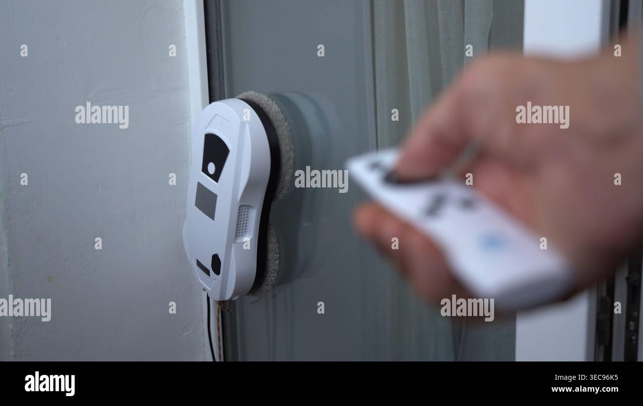 Un robot per la pulizia di finestre high-tech controllato da remoto: Scopri la semplicità delle soluzioni di pulizia automatizzate per le finestre di casa e ufficio Foto Stock