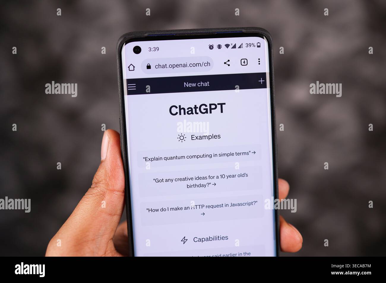 Primo piano dello schermo ChatGPT sul telefono in modalità bianca tenendo la mano sinistra su uno sfondo scuro, esplorando ChatGPT sullo schermo di uno smartphone. Foto Stock