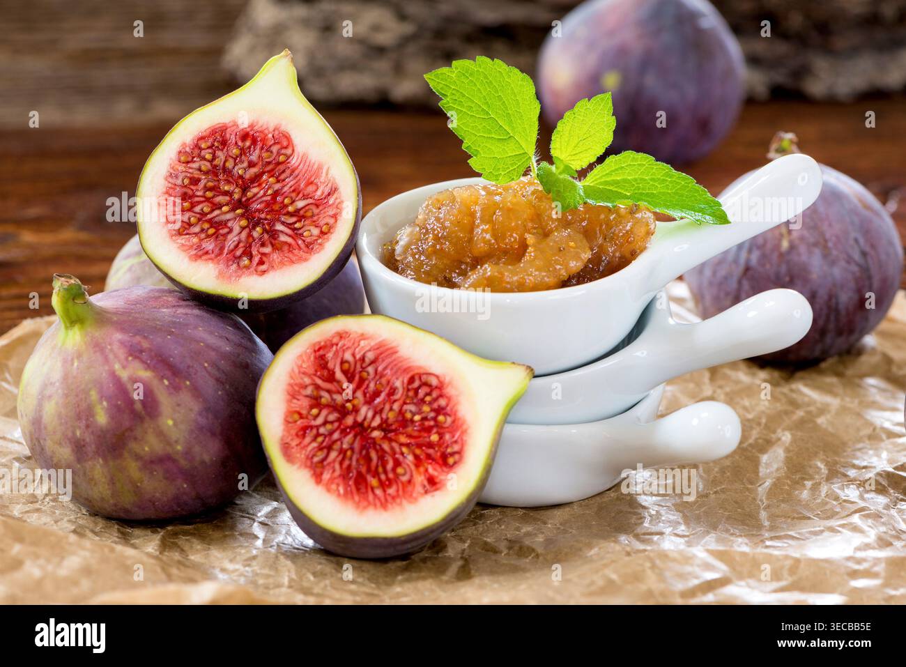 Fichi commestibili, fichi comuni (Ficus carica), marmellata di fichi fatta in casa in piccoli recipienti con fichi freschi, guarnita con balsamo al limone Foto Stock