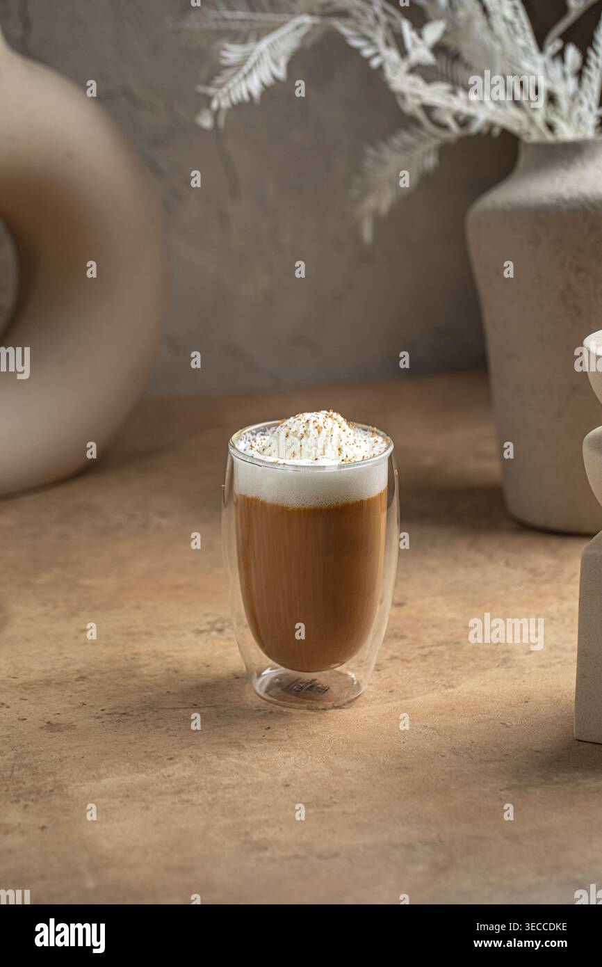 Caffè latte con schiuma in una tazza di vetro Foto Stock