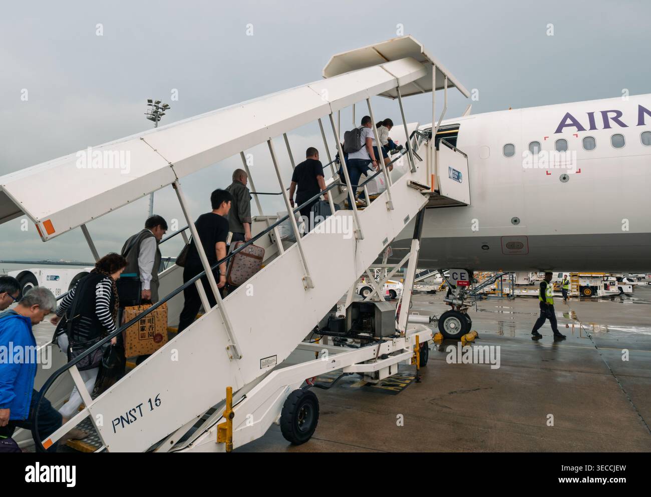 Macao, Cina - 8 maggio 2018: Passeggeri che si imbarcano su un aereo utilizzando scale aeree portatili in una giornata nuvolosa all'aeroporto Foto Stock