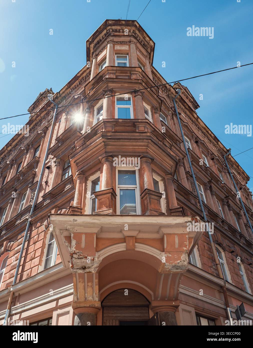 Edificio della città vecchia, con architettura ornata e colonne decorative illuminate dal sole Foto Stock