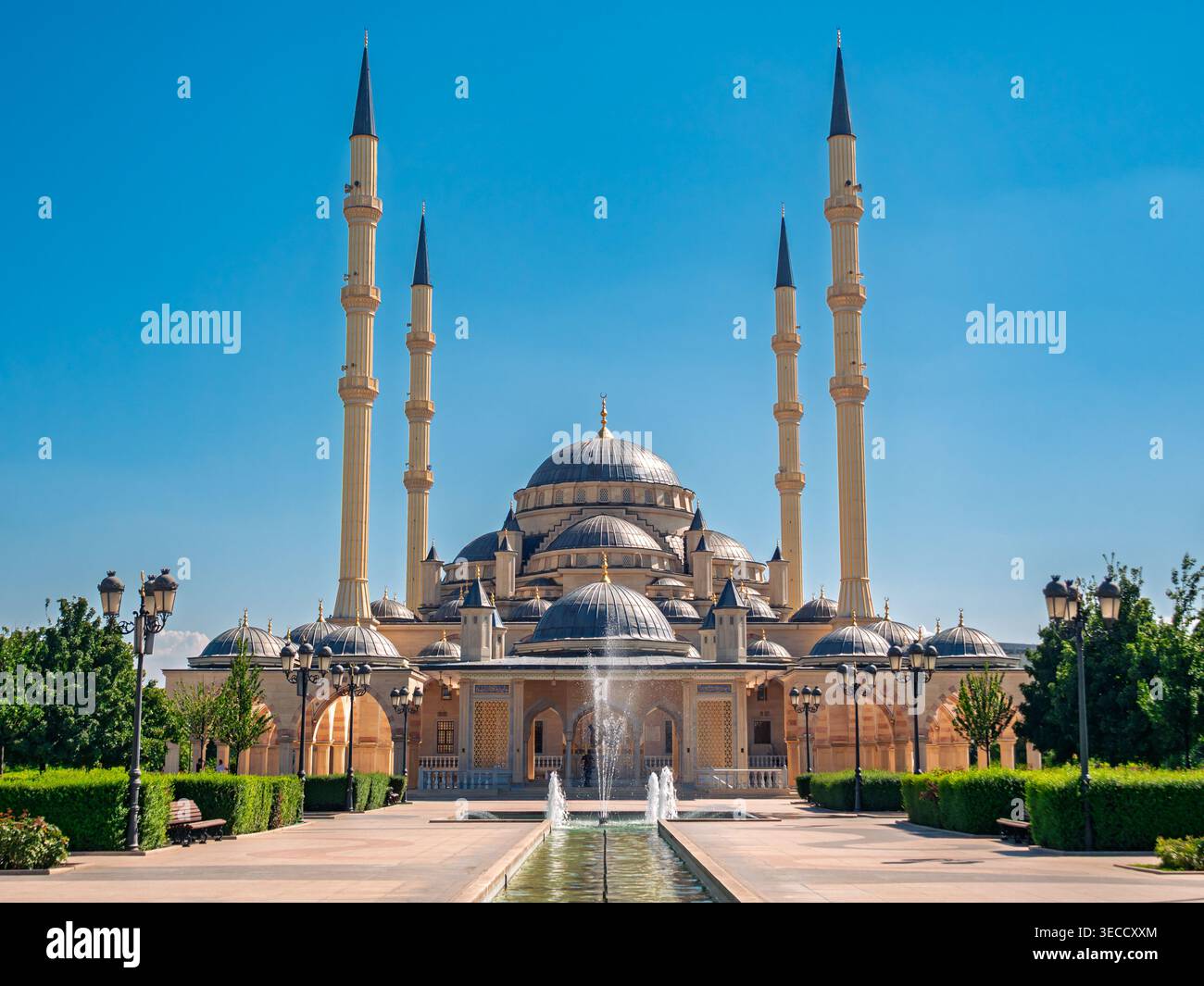 Grozny, Russia - 30 luglio 2021: La maestosa moschea Akhmad Kadyrov e la sua piscina riflettente sotto un cielo azzurro Foto Stock