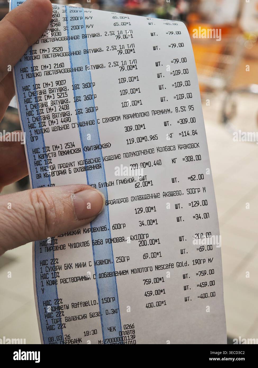 Kirov, Russia - 8 marzo 2026: Un cliente è in possesso di una ricevuta dettagliata di un negozio di alimentari che elenca i vari prodotti alimentari e i relativi costi dopo l'acquisto presso Foto Stock