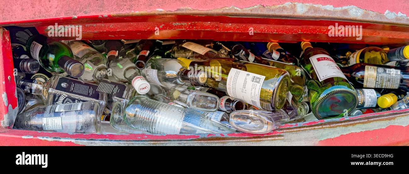 Pontypridd, Rhondda Cynon Taf, Galles, Regno Unito - 21 marzo 2026: Vista panoramica delle bottiglie vuote di vino e liquori in un contenitore di riciclaggio pieno. - Immagine stock catturata con smartphone