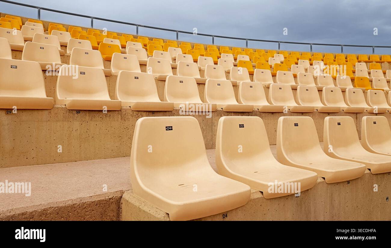 File di posti vuoti gialli e bianchi all'aperto Stadium Foto Stock