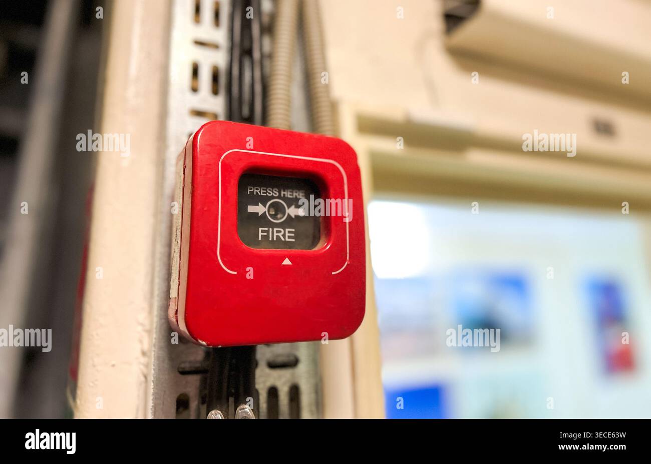 Segnale rosso del sistema di allarme antincendio. Premere qui in caso di incendio. Segnale di sicurezza di emergenza in primo piano. Foto Stock