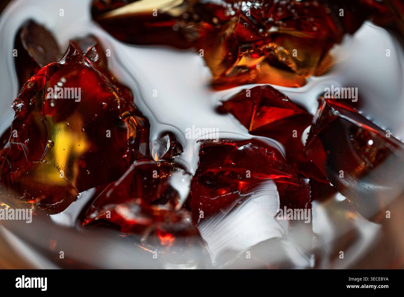 Whiskey ghiaccio macro consistenza ambrata liquido fondo alcolico astratto Foto Stock
