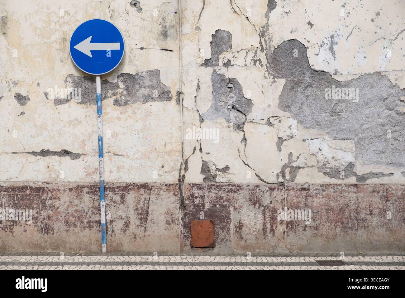 Cartello di sola andata di fronte a un muro in rovina a Funchal, Madeira Foto Stock