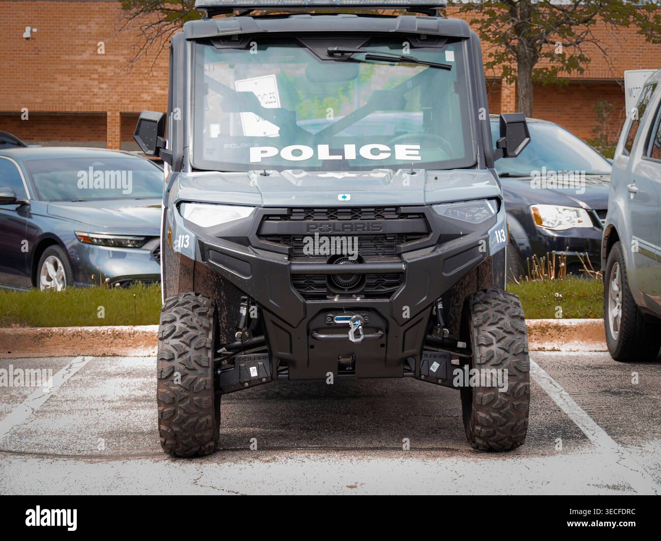 Vista frontale del veicolo UTV specializzato nella polizia nel parcheggio Polaris Ranger modificato con decalcomanie polizia pneumatici fuoristrada barra luminosa e verricello Foto Stock