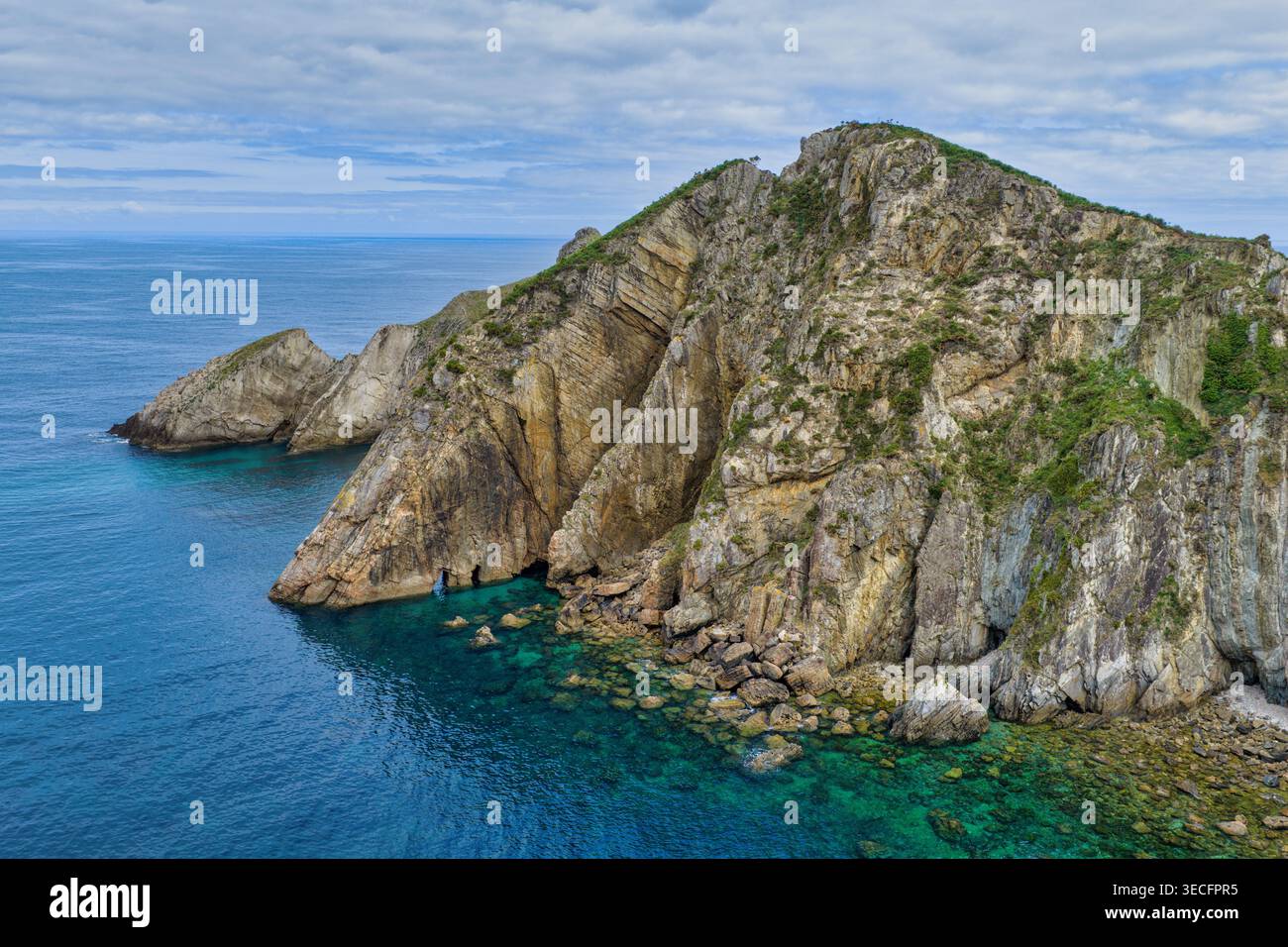 Vista aerea del punto panoramico di Silence Beach con scogliere rocciose e acque turchesi sotto un cielo nuvoloso a Cudillero, nelle Asturie, in Spagna. Foto Stock
