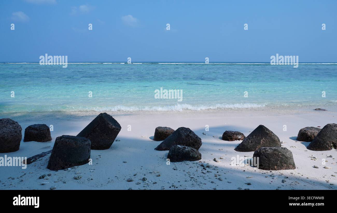 la bellezza paesaggistica della spiaggia di sabbia bianca con il demolitore di onde tetrapodi Foto Stock