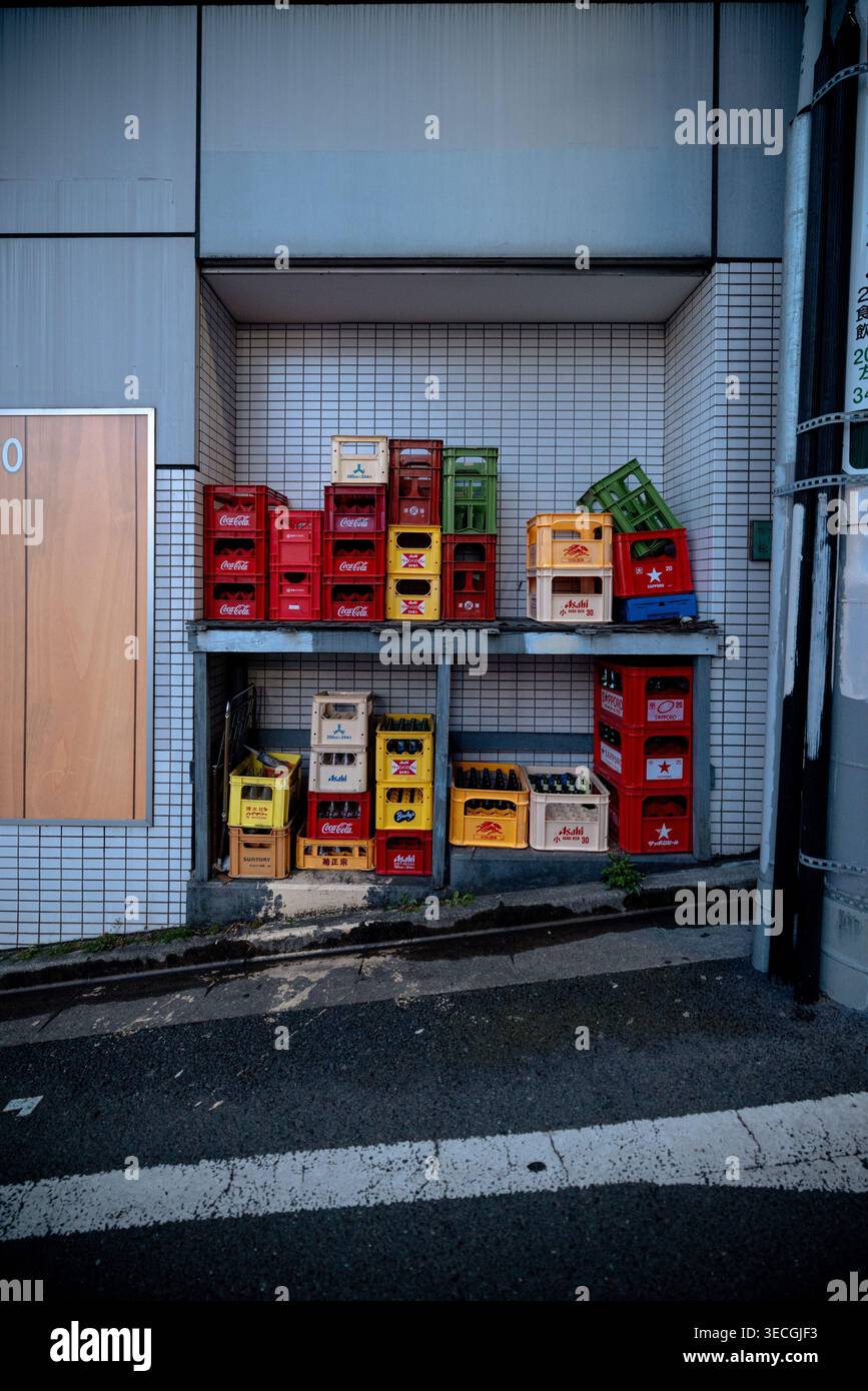 Casse impilate per la consegna di bevande accanto al negozio nel quartiere Shibuya di Tokyo, Giappone Foto Stock