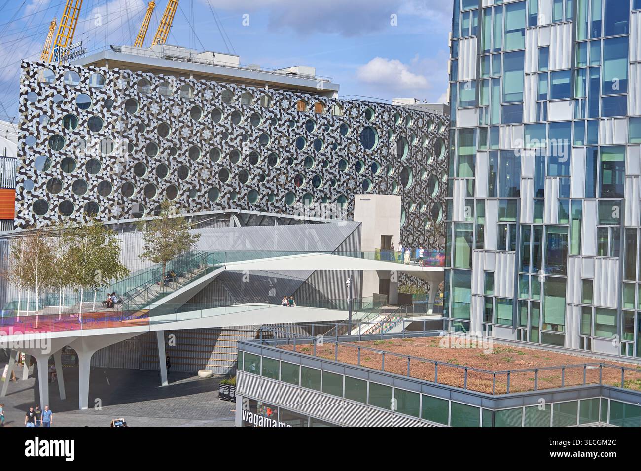 Complesso architettonico moderno che presenta l'edificio della Ravensbourne University London con una distintiva facciata in metallo perforato decorata con motivi circolari Foto Stock