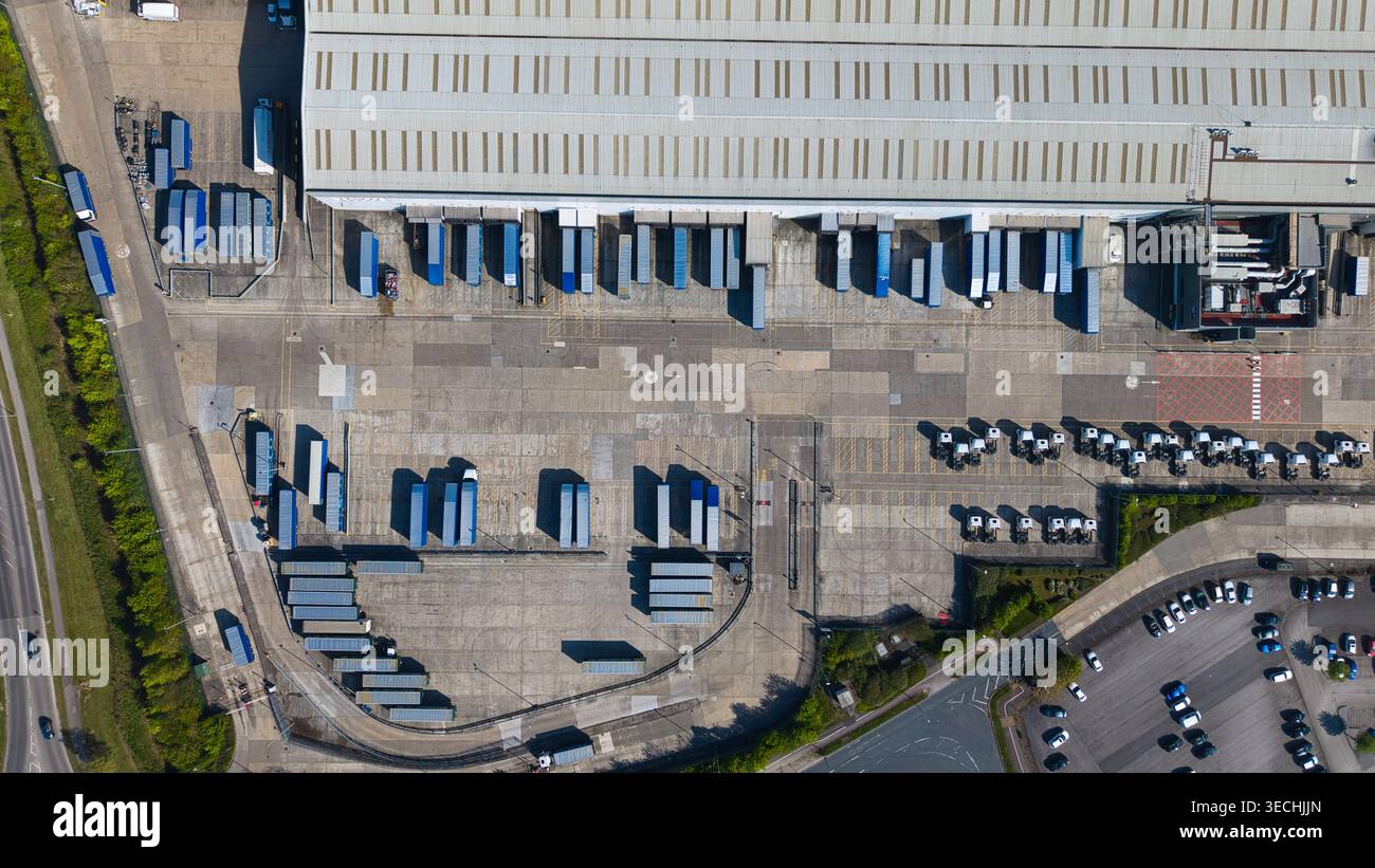 Vista aerea di un grande magazzino industriale con numerose banchine di carico, semirimorchi blu e camion parcheggiati in un centro di distribuzione di Goole, Inghilterra Foto Stock