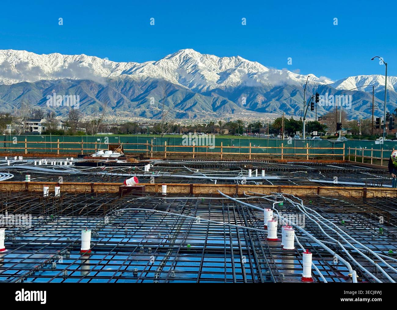 Lastra di podio da costruzione con tondino e servizi pubblici in costruzione con montagne innevate sullo sfondo Foto Stock