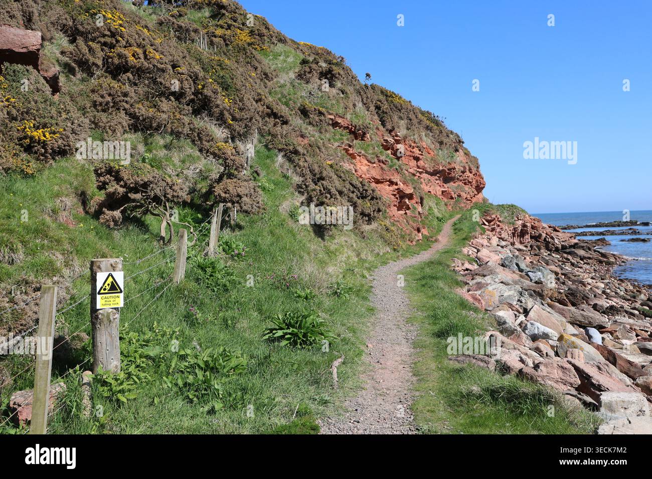 Cartello segnaletico per gli scivoli rocciosi accanto al sentiero costiero dell'Aberdeenshire vicino a Johnshaven, Scozia, aprile 2026 Foto Stock
