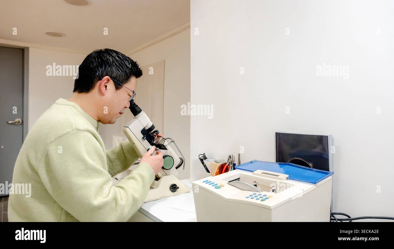Un meticoloso tecnico di laboratorio esamina gli occhiali al microscopio in un centro ottico, garantendo precisione artigianale e soddisfazione del cliente Foto Stock