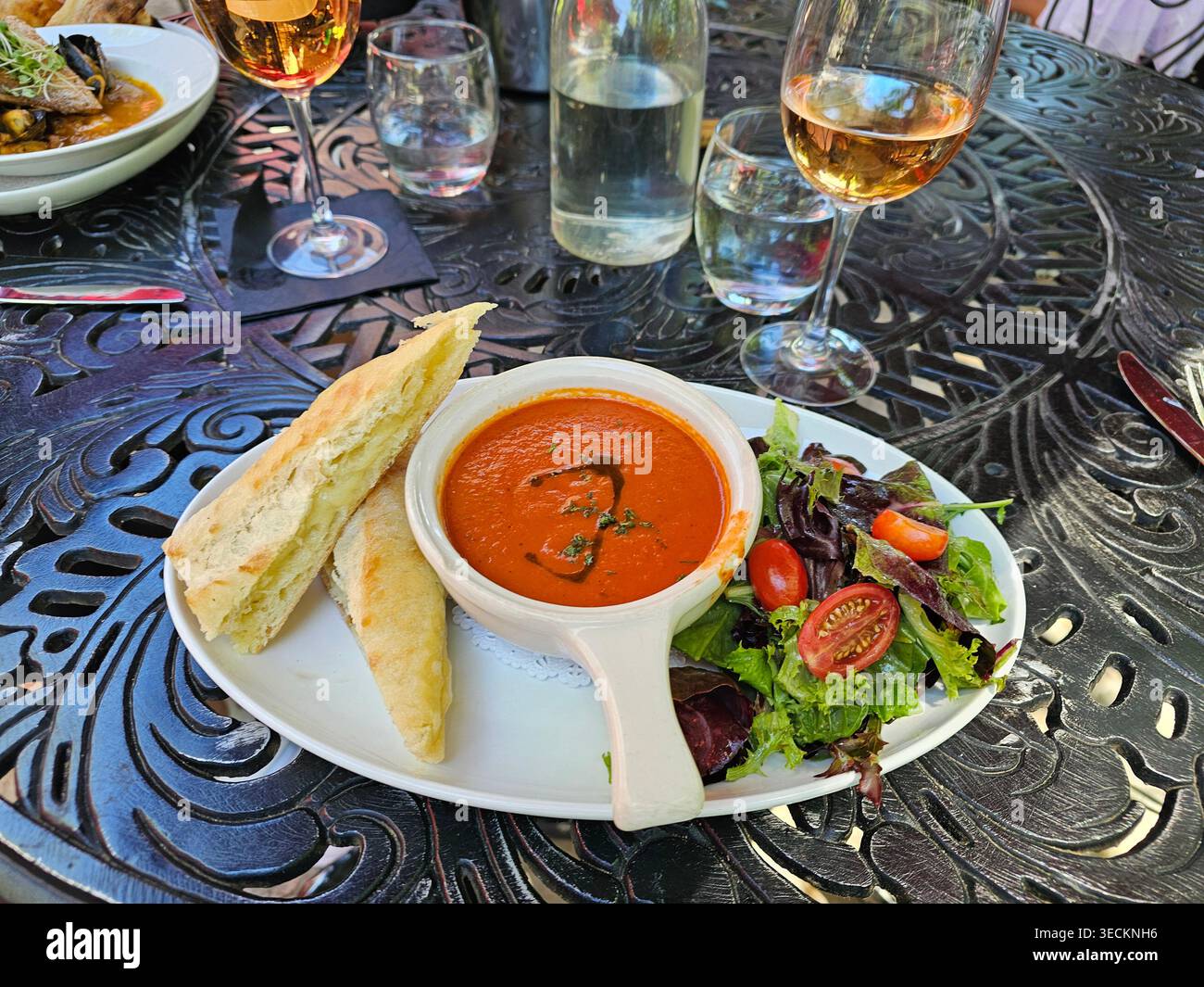 Panino al formaggio alla griglia con pane grassa e francese, accompagnato da una zuppa di pomodori spessa e un'insalata di foglie primaverili e pomodori. Foto Stock